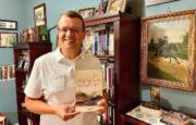 Jonathan Noyalas holds a copy of his new book, "The Blood-Tinted Waters of the Shenandoah."